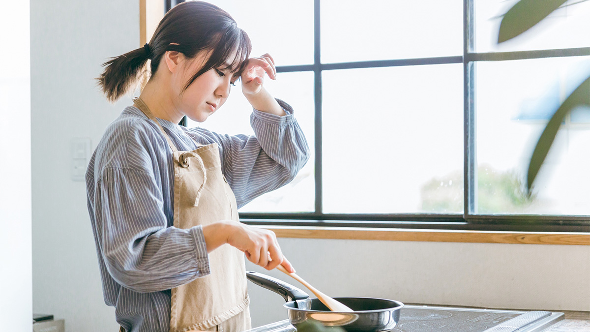 調理中に疲れやストレスを感じている女性