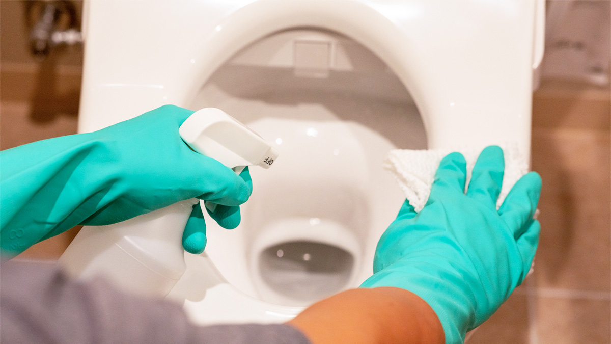 ゴム手袋をしてトイレ掃除をしているイメージ