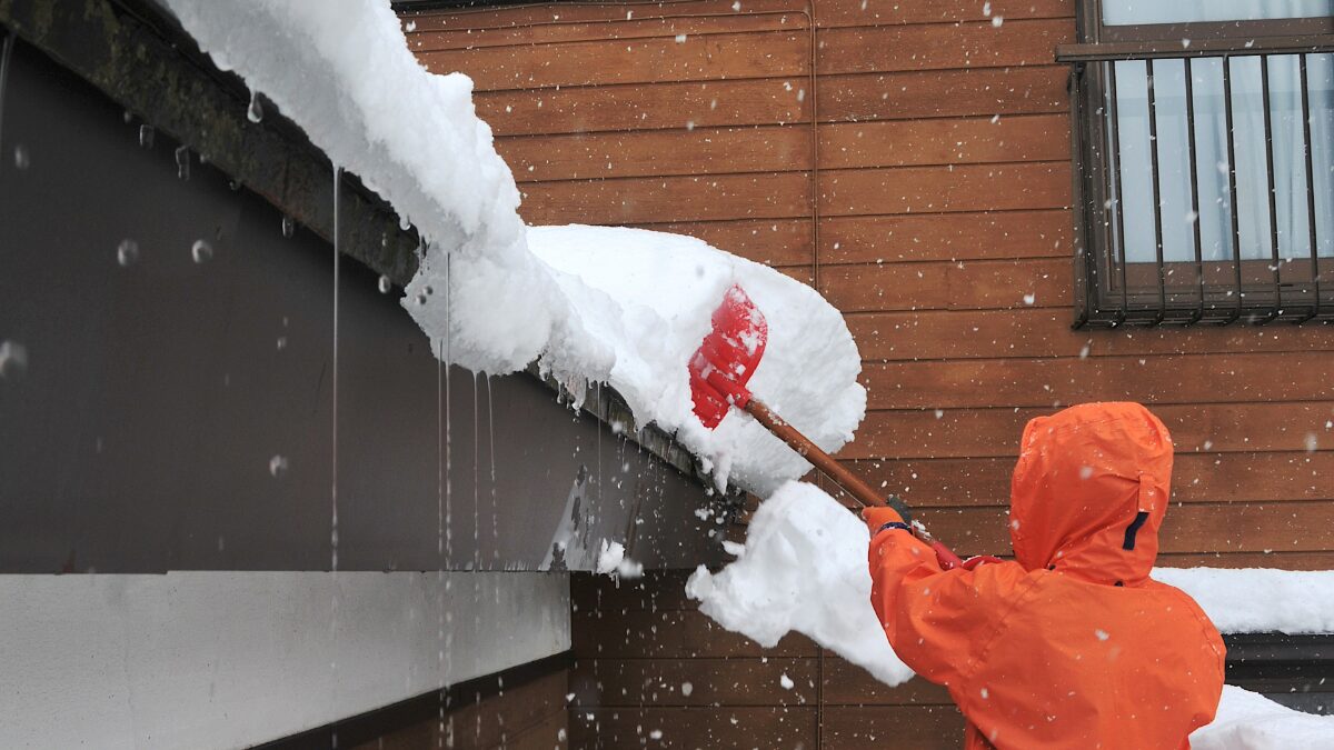 屋根上の雪庇を落とす様子